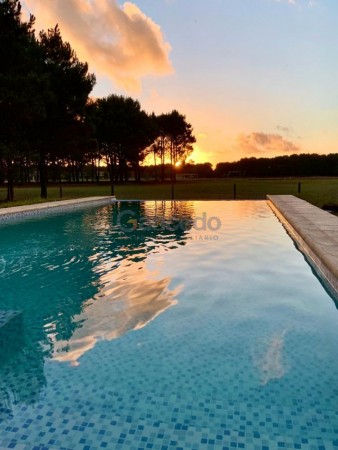  Casa en Venta en La Herradura, Pinamar: Arquitectura Elegante, Balcon con Vista a la Cancha de Polo y Pileta Climatizada